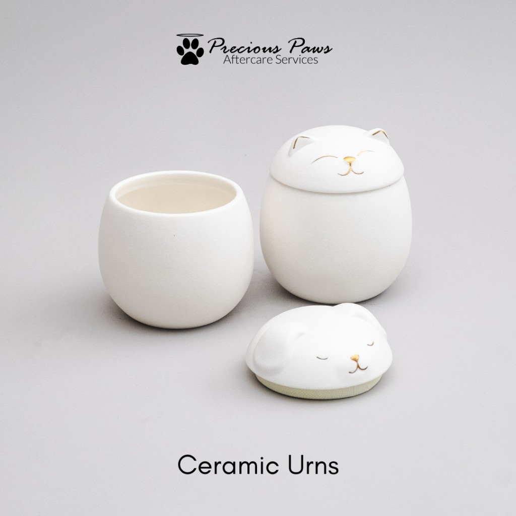 White ceramic dog and cat urns shown open and closed